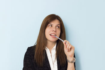 Business woman biting on pen