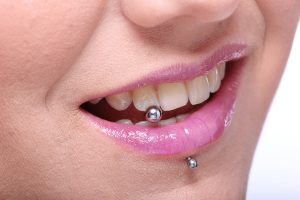 woman shows her piercing